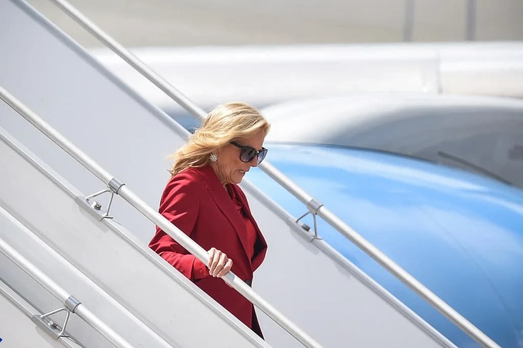 US First Lady Jill Biden walks down aircraft steps.